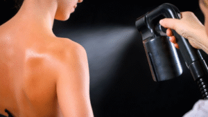 Client receiving spray tanning treatment from a trained beauty therapist